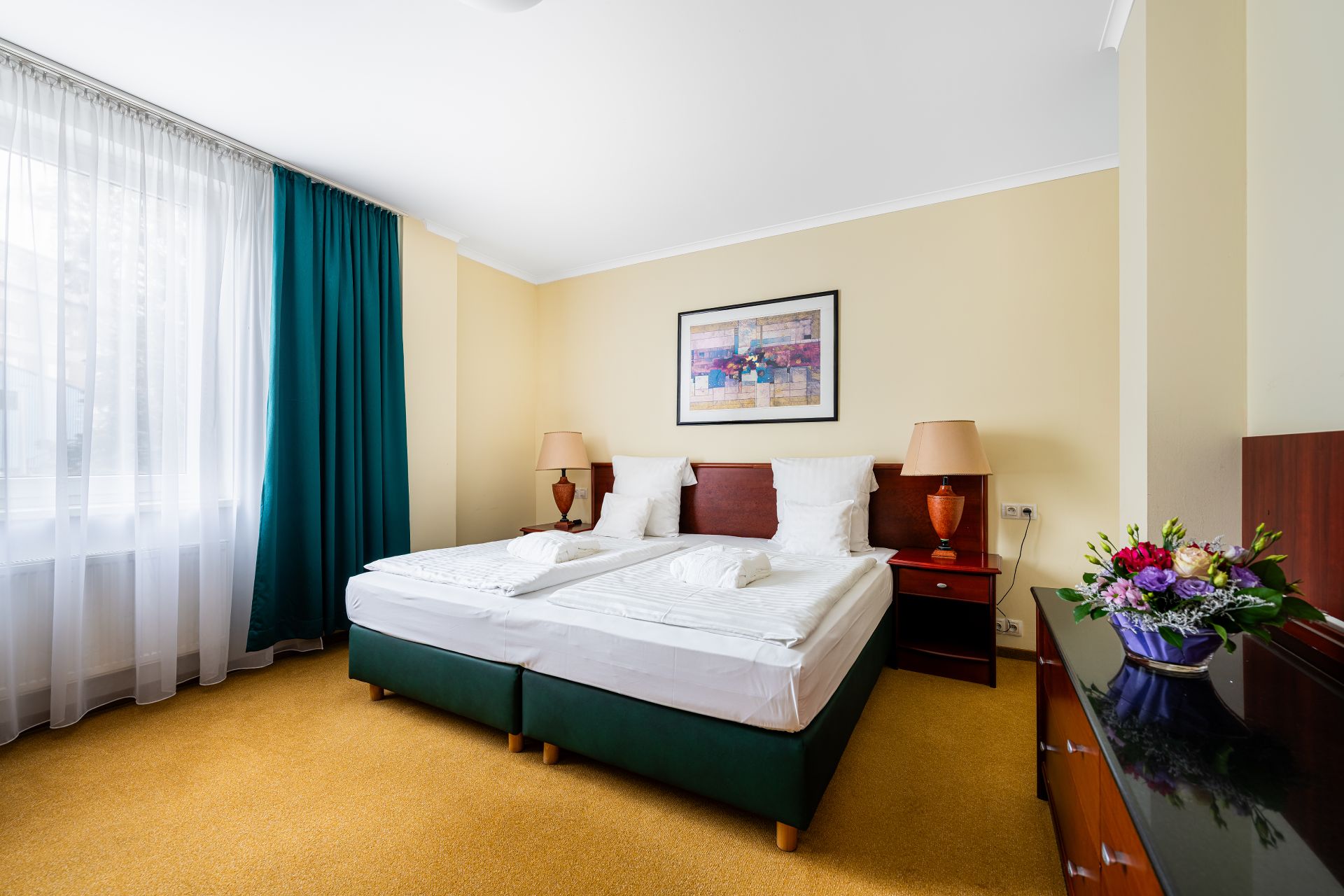 Luxusní hotelový pokoj s manželskou postelí a elegantním nábytkem v hotelu Karlovy Vary